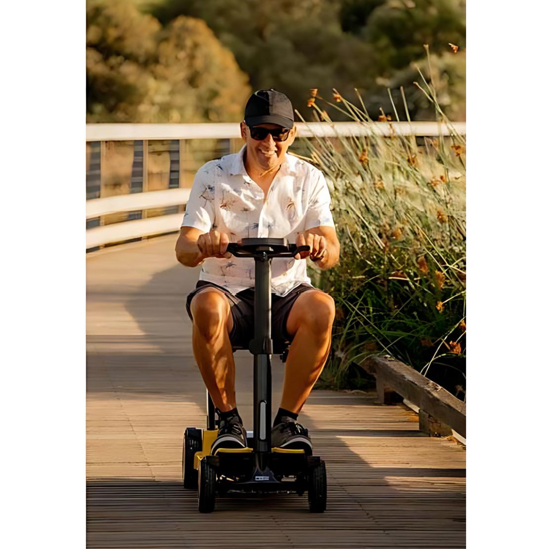 Man riding a Pride Go Go Carbon scooter on a boardwalk